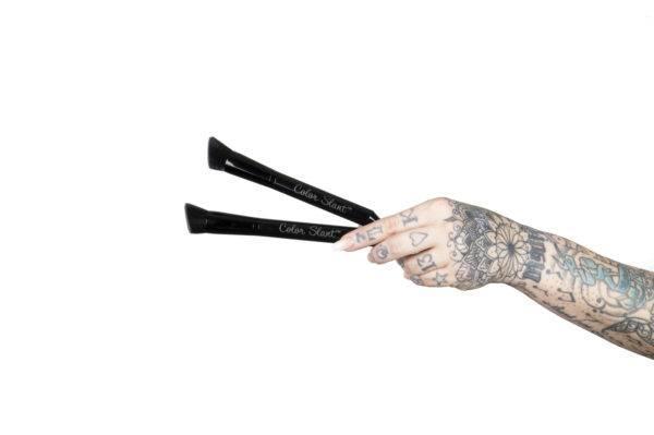 Hands holding several hair color brush